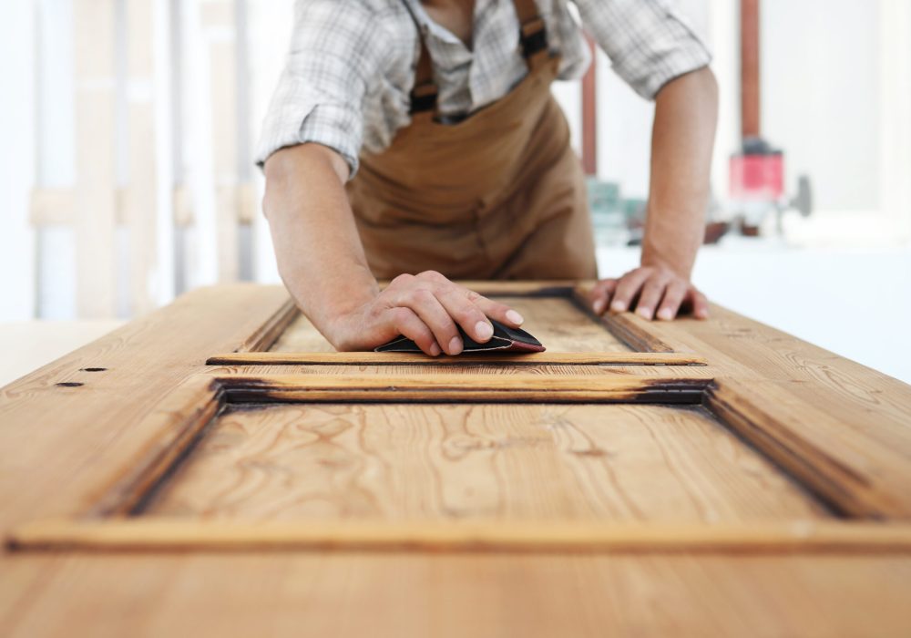 carpenter work the wood with the sandpaper